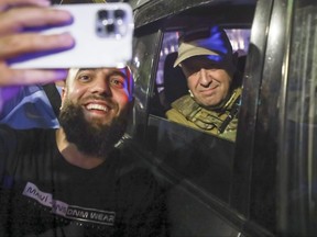 Yevgeny Prigozhin est assis à l'intérieur d'un véhicule militaire posant pour une photo de selfie avec un local