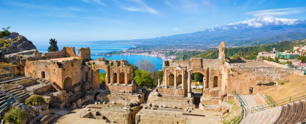 Ruins of Ancient Greek theatre in Taormina on background of Etna Volcano, Italy. Taormina located in Metropolitan City of Messina, on east coast of island of Sicily.