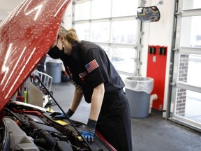 Un employé travaille sous le capot d'un véhicule dans un site de Valvoline Inc. Instant Oil Change à Indianapolis, Ind.