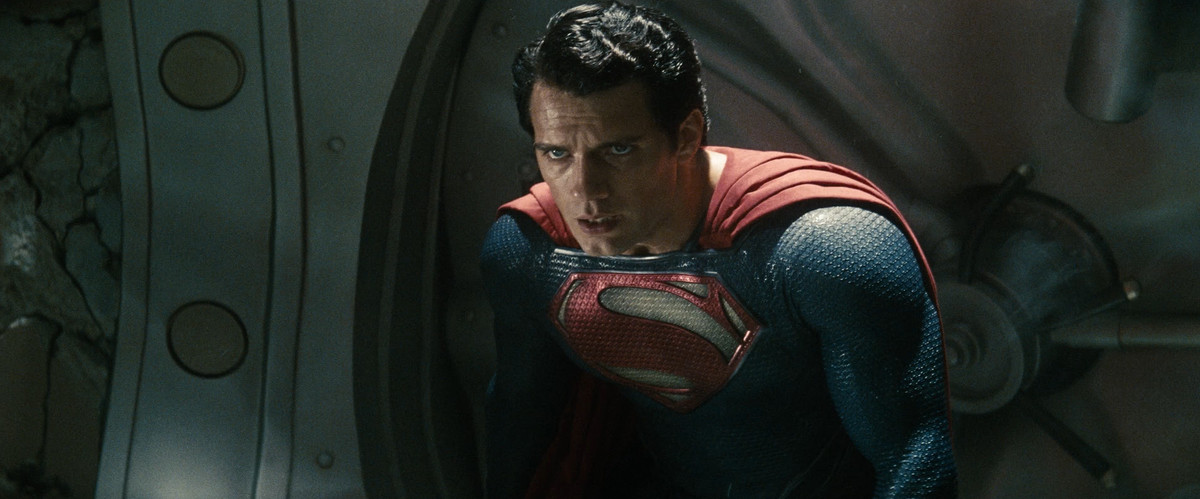Henry Cavill dans Man of Steel, vêtu de sa tenue de Superman et courbé, épuisé