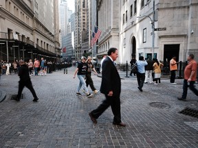 Les gens marchent le long de Wall Street par la Bourse de New York à New York.