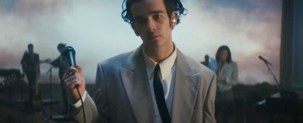 Matty Healy holding a mic in the Part of the Band performance by The 1975.