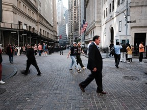 Les gens marchent le long de Wall Street près de la Bourse de New York.  Les chefs de Wall Street ont été parmi les plus bruyants à faire pression pour un retour au bureau cinq jours par semaine.
