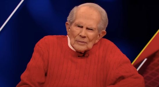 Pat Robertson in a red sweater, during a broadcast of The 700 Club.
