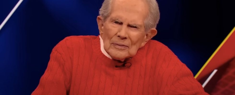 Pat Robertson in a red sweater, during a broadcast of The 700 Club.