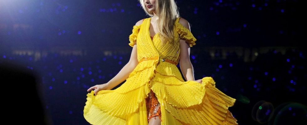 Taylor Swift showing off her yellow duster on the Eras Tour.