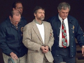 Theodore Kaczynski regarde autour de lui alors que les US Marshals se préparent à descendre les marches du palais de justice fédéral jusqu'à un véhicule en attente le 21 juin 1996 à Helena, dans le Montana.