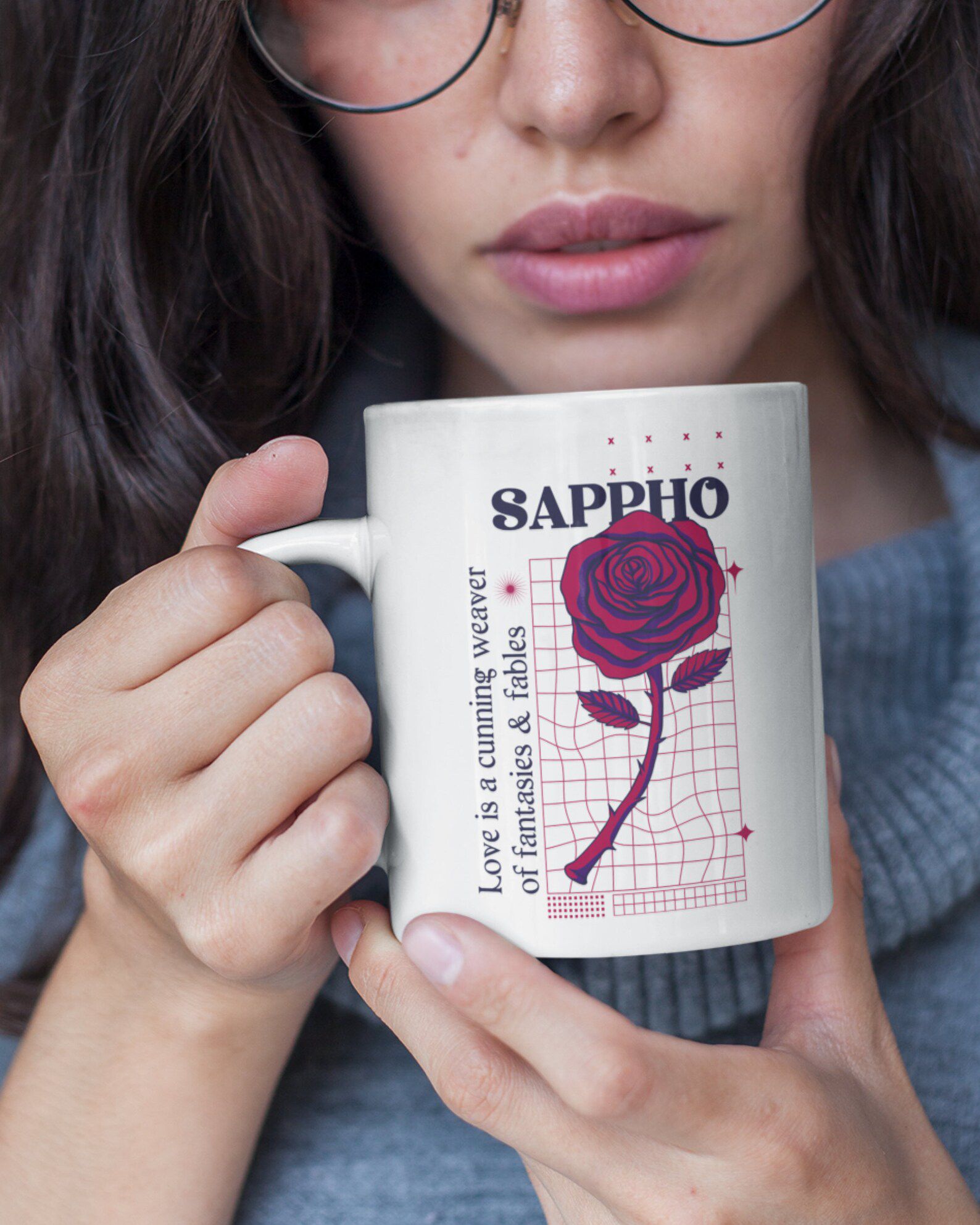 Image d'une tasse avec une rose honorant Sappho.  Il est tenu par une personne à la peau mate. 