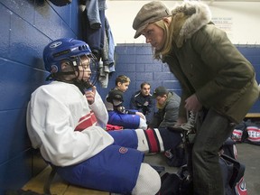 Leanne Domi attache les patins de son fils Max avant un entraînement de hockey, le samedi 28 février 2004