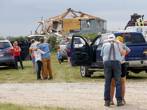 Les résidents se réconfortent après qu'une tornade a détruit leur propriété sur l'autoroute 2A entre Didsbury et Beiseker le samedi 1er juillet 2023.