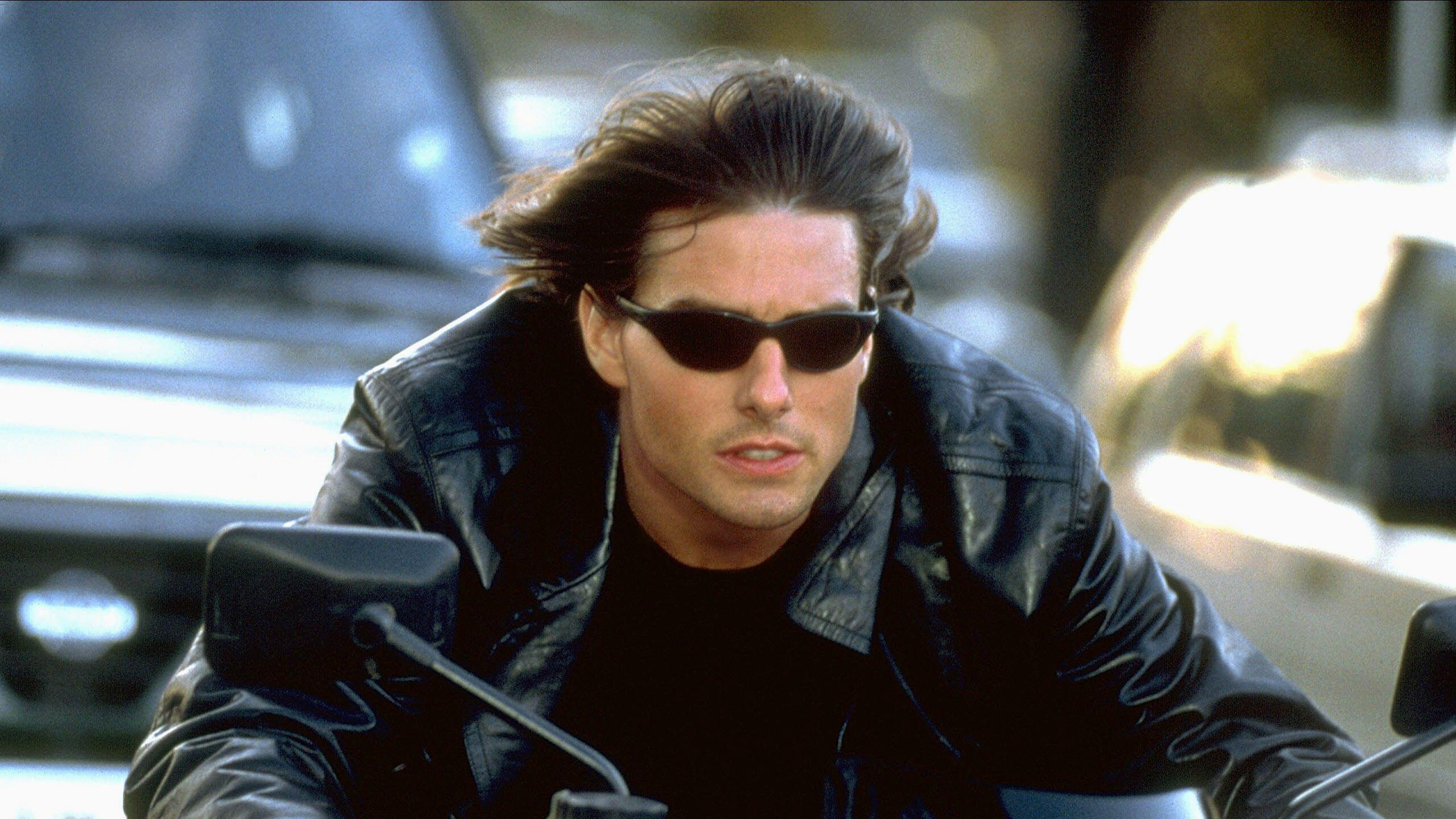 Tom Cruise dans le rôle d'Ethan Hunt sur une moto portant des lunettes de soleil dans Mission : Impossible 2