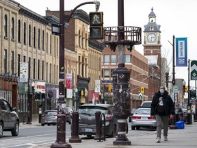 Un homme marche au centre-ville de Peterborough, en Ontario.