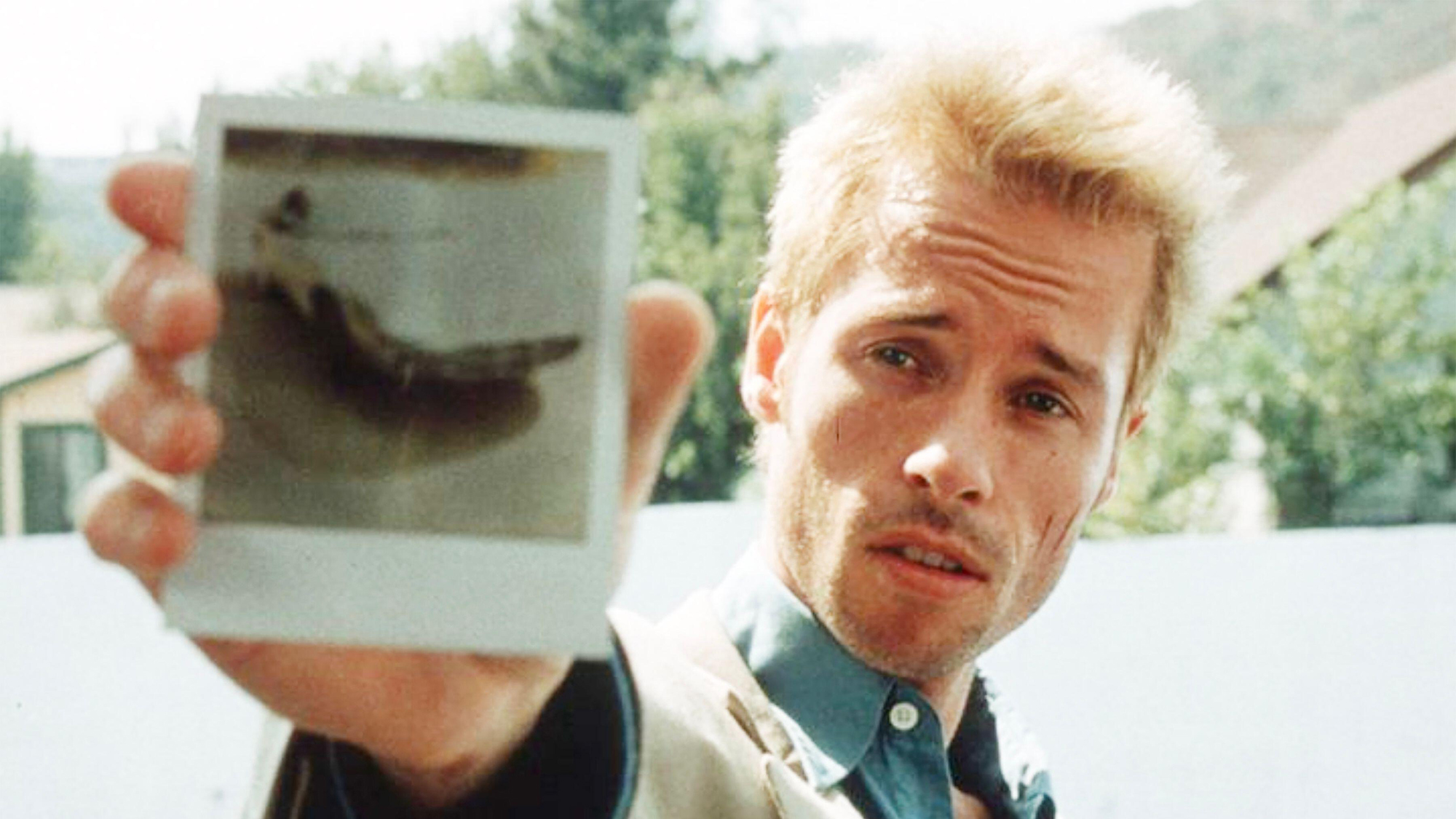 Guy Pearce dans le rôle de Leonard tenant une photo polaroid dans Memento
