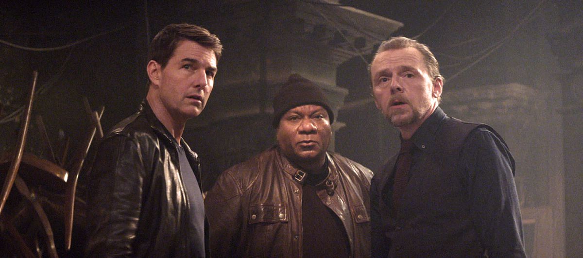 Ethan Hunt (Tom Cruise), Luther Stickell (Ving Rhames, dans un bonnet noir et une veste en cuir) et Simon Pegg (dans un costume noir sur noir) se tiennent en demi-cercle dans Mission: Impossible Dead Reckoning Part One