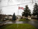 Un drapeau canadien devant des maisons dans un quartier de Toronto.  La dernière hausse des taux de la Banque du Canada infligera davantage de souffrances aux propriétaires.