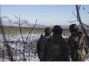 Des soldats ukrainiens regardent la fumée s'échapper lors des combats entre les forces ukrainiennes et russes à Soledar, dans la région de Donetsk, en Ukraine, le mercredi 11 janvier 2023.