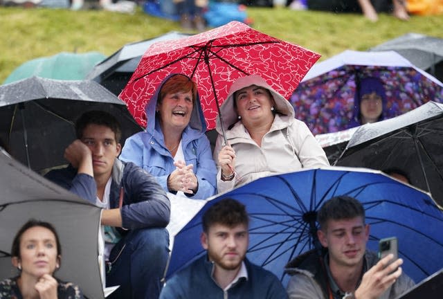 Spectateurs regardant Wimbledon sous des parapluies