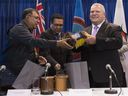 Le premier ministre de l'Ontario, Doug Ford, à droite, le chef Cornelius Wabasse, de la Première Nation Webequie, à gauche, et le chef Bruce Achneepineskum, de la Première Nation de Marten Falls, au centre, s'offrent des cadeaux après leur accord signé concernant un projet de route du Cercle de feu.