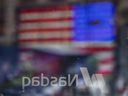 Un drapeau américain se reflète dans la fenêtre du Nasdaq MarketSite à New York.