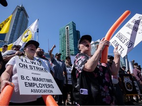 Les travailleurs portuaires en grève de l'International Longshore and Warehouse Union Canada applaudissent alors que les conférenciers encouragent la foule lors d'un rassemblement à Vancouver, le dimanche 9 juillet 2023.