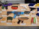 Une gamme d'armes imprimées en 3D en plastique coloré est visible sur une photo de la police du mardi 11 juillet 2023.  Sont incluses des répliques d'armes à feu fabriquées dans le commerce, notamment un fusil AR-15 et des armes de poing des fabricants d'armes Glock et Smith & Wesson.