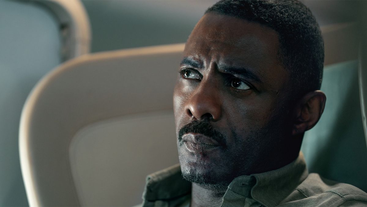 Idris Elba dans le rôle de Sam Nelson assis dans un avion dans Apple TV Plus' Hijack