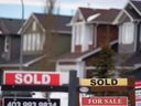 Panneaux immobiliers « à vendre » et « vendus » dans la banlieue de Calgary.