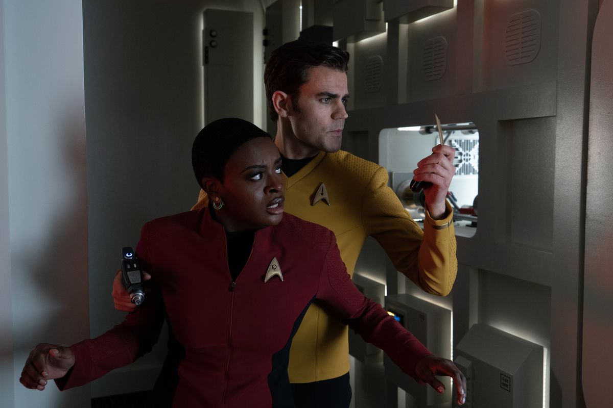 Uhura (Celia Rose Gooding) debout devant Kirk (Paul Wesley) qui vérifie son transpondeur