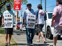 Des travailleurs portuaires en grève appartenant à l'International Longshore and Warehouse Union Canada marchent sur la ligne de piquetage près de l'entrée Clark Dr. du port de Vancouver à Vancouver, en Colombie-Britannique, le 1er juillet 2023.