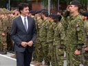 Le premier ministre Justin Trudeau inspecte les troupes canadiennes sur une base militaire à Adazi, en Lettonie, le 10 juillet 2023.