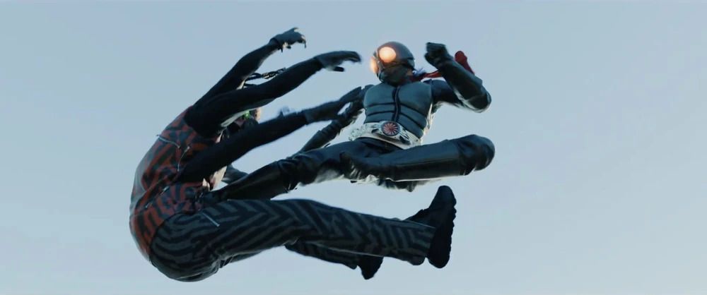 Kamen Rider (Sosuke Ikematsu) délivrant un coup de pied en l'air au torse de Kumo Augment-01 (Nao Omori) dans Shin Kamen Rider