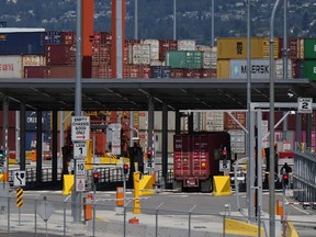 Un camion de transport transporte un conteneur de fret jusqu'au terminal à conteneurs Centerm du port de Vancouver, le vendredi 14 juillet 2023.