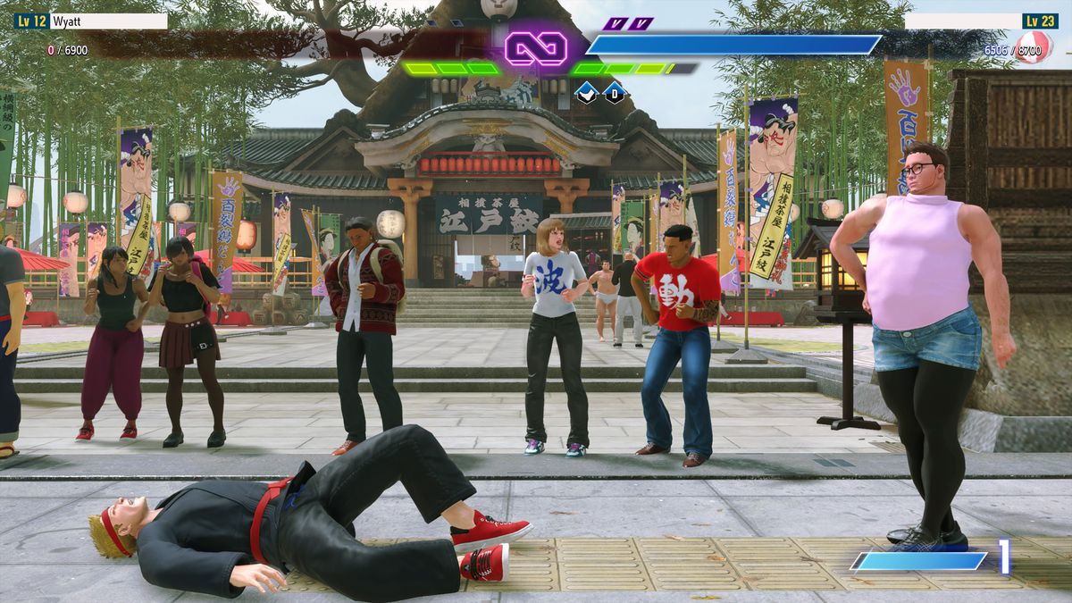 À gauche, un personnage de Street Fighter 6 dans un gi noir allongé sur le sol après la défaite d'après-match, avec le personnage de Street Fighter 6 de l'écrivain à droite avec la main sur la hanche de son short en jean, porté avec des collants noirs et un débardeur rose