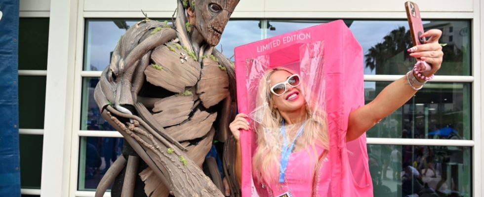 Cosplayers dressed as Groot and Barbie take a selfie at the 2023 Comic-Con International: San Diego at the San Diego Convention Center on July 22, 2023 in San Diego, California.