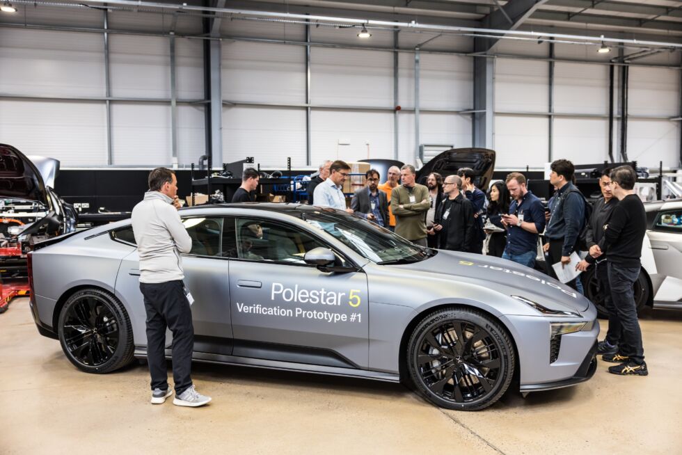 Pete Allen, responsable de la R&D de Polestar UK (chemise bleue) se tient derrière un prototype de Polestar 5 et s'entretient avec des journalistes réunis.
