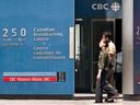 Des piétons marchent devant l'édifice de la CBC au centre-ville de Toronto. 
