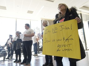 Karlene Gibson tient une pancarte lors d'un rassemblement à l'hôtel de ville de Regina le 5 avril 2023. Un examen indépendant de la façon dont l'agence de tourisme de Regina a géré un changement de marque raté indique qu'un employé subalterne a approuvé des slogans sexualisés avant que la haute direction ne puisse les examiner officiellement.