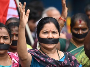Des manifestants avec des bandes noires couvrant la bouche crient des slogans lors d'une manifestation contre les violences sexuelles contre les femmes à Manipur le 22 juillet 2023.