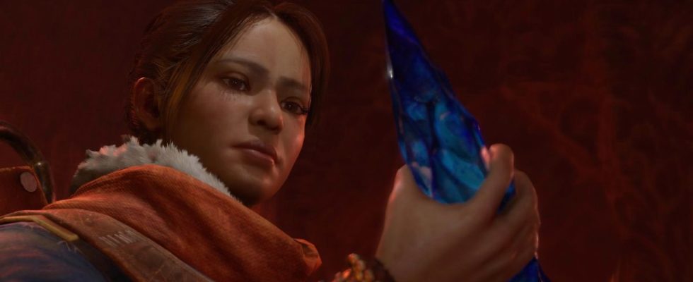 Neyrelle - a determined young woman from Diablo 4 - holds a fiendish soul crystal.