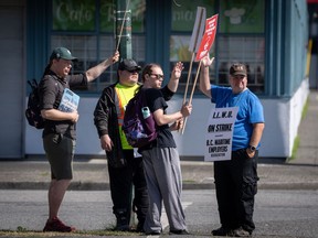 Les travailleurs de l'International Longshore and Warehouse Union saluent les voitures qui passent devant le centre de répartition de la BC Maritime Employers Association après un préavis de grève de 72 heures et aucune entente conclue à la table de négociation à Vancouver, le samedi 1er juillet 2023.