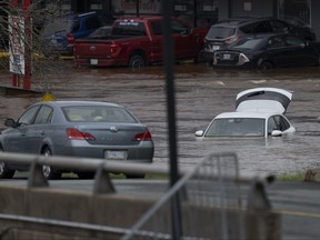 Des voitures abandonnées dans le stationnement d'un centre commercial sont vues dans les eaux de crue à la suite d'un événement pluvieux majeur à Halifax le samedi 22 juillet 2023.