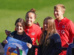Julia Grosso du Canada, à gauche, et Quinn posent pour une photo avec des partisans lors d'une séance d'entraînement avant la Coupe du monde féminine de la FIFA