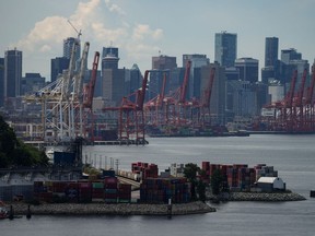 Des grues à portique sont inactives au-dessus de piles de conteneurs de fret au port lors d'une grève des travailleurs de l'International Longshore and Warehouse Union Canada dans la province, à Vancouver, le mercredi 12 juillet 2023.