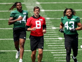 Aaron Rodgers (au centre) s'échauffe avec ses coéquipiers des Jets de New York à l'entraînement.