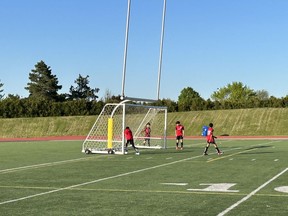 De jeunes joueurs de soccer mettent un filet en place au Centennial Park à Toronto le 25 mai 2023.
