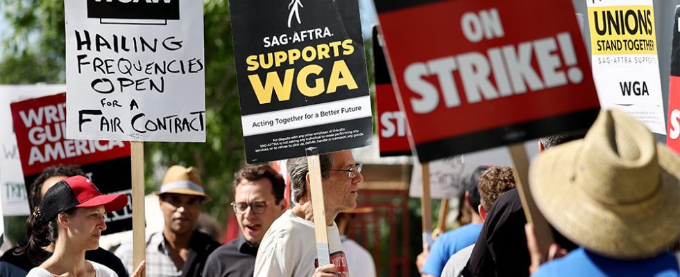 LOS ANGELES, CALIFORNIA - JULY 13: A sign reads 'SAG-AFTRA Supports WGA' as SAG-AFTRA members walk the picket line in solidarity with striking WGA (Writers Guild of America) workers outside Netflix offices on July 13, 2023 in Los Angeles, California. Members of SAG-AFTRA, Hollywood’s largest union which represents actors and other media professionals, will likely go on strike after a midnight deadline over contract negotiations with studios expired. The strike could shut down Hollywood productions completely with writers in the third month of their strike against Hollywood studios. (Photo by Mario Tama/Getty Images)