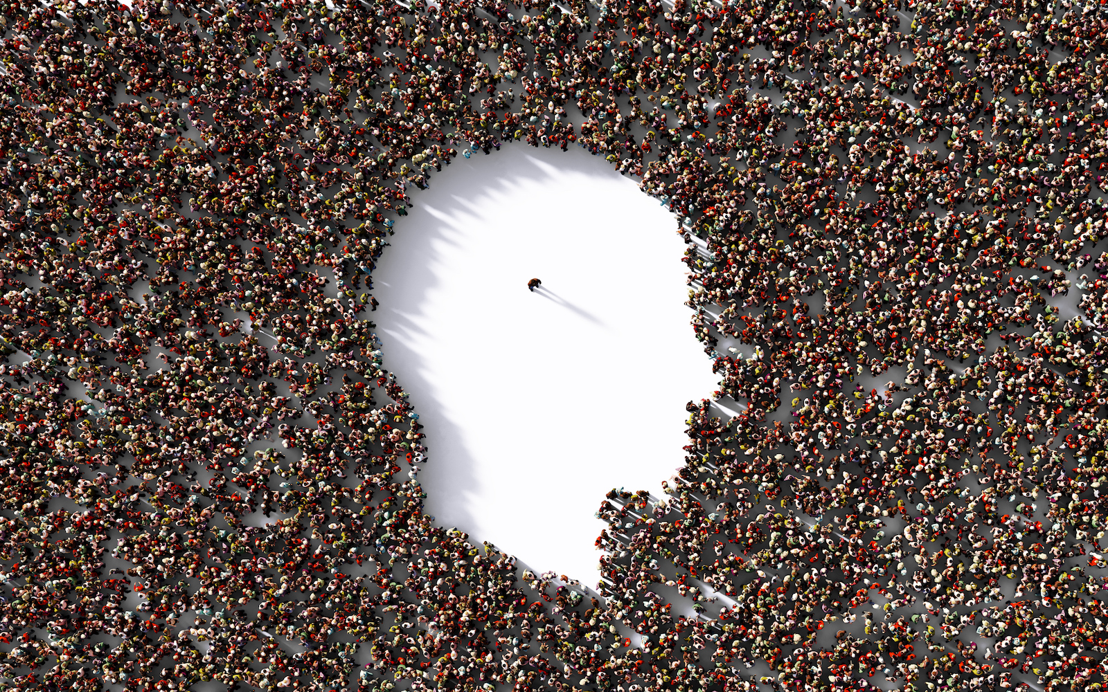 Homme célibataire debout à l'intérieur d'une forme de tête humaine formée par une foule humaine sur fond blanc.  Composition horizontale avec chemin de détourage et espace de copie.