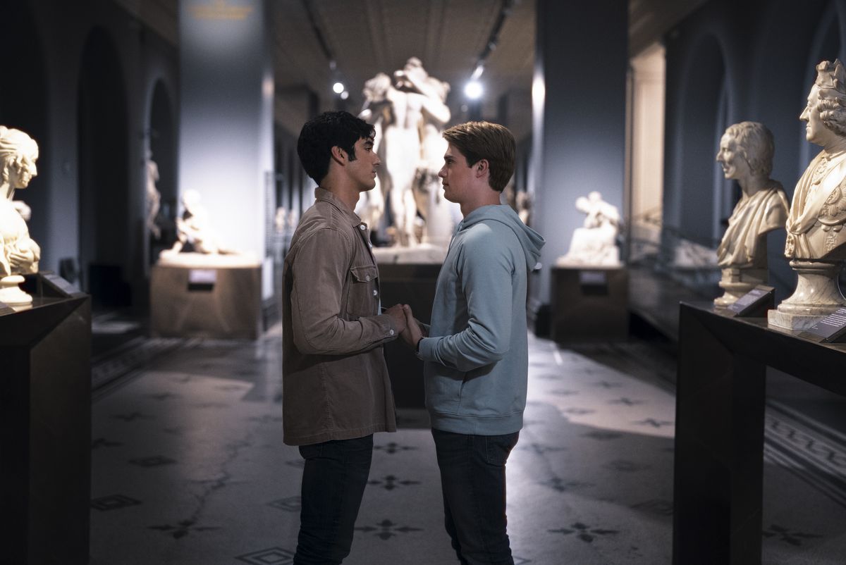 Alex et Henry debout dans un musée vide, main dans la main