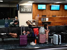 Les passagers tentent de se reposer en attendant des vols retardés et annulés au large de l'île alors que des milliers de passagers se sont retrouvés bloqués à l'aéroport de Kahului à Maui, Hawaï, cette semaine.