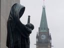 La statue représentant la justice regarde de la Cour suprême du Canada sur la Cité parlementaire à Ottawa.
